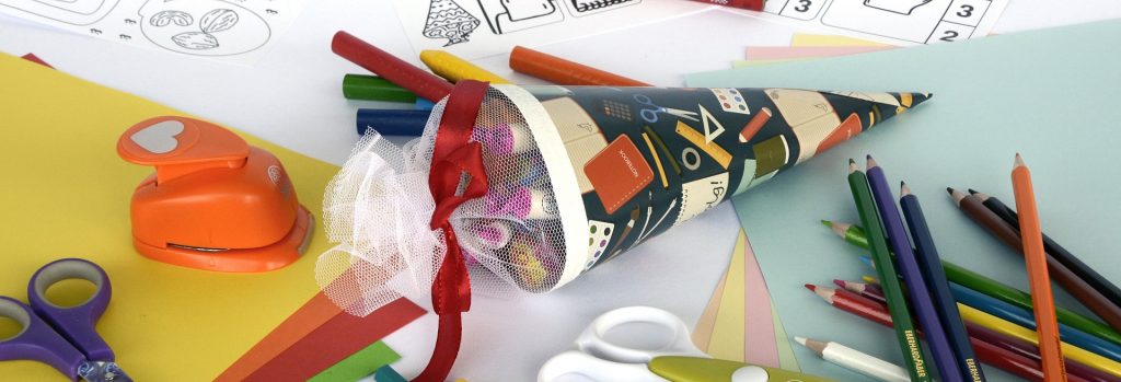 Manualidad de cartón junto a lápices de colores y tijeras
